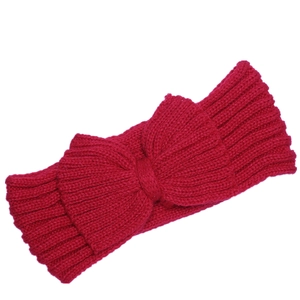 Close-up of red knitted headband featuring a large bow and ribbed wool texture
