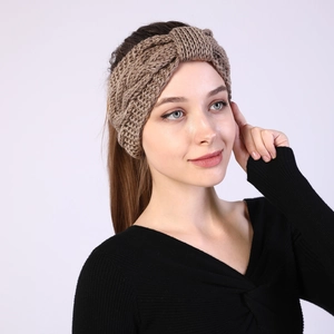 Close-up of brown cable knit headband showing thick wool texture and twist knot detail