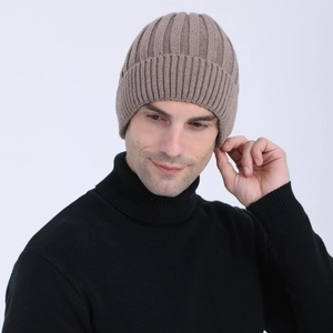 Close-up of khaki ribbed knit beanie texture with thick wool yarn for winter warmth
