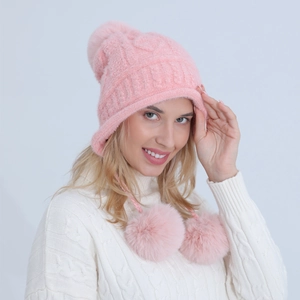 Dettaglio della maglia rosa del cappello con paraorecchie e pompon in finta pelliccia
