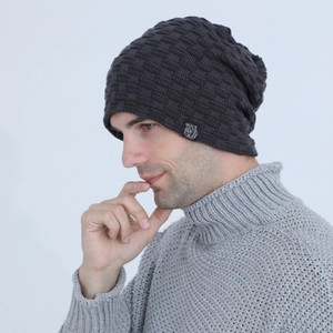 Detail of dark grey knit beanie featuring a square bear logo patch and textured pattern
