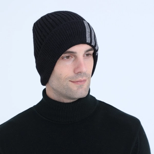 Detail of black ribbed knit beanie featuring three grey vertical stripes on the side