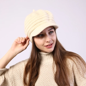Detail view of beige striped knit visor beanie with soft thermal texture on model