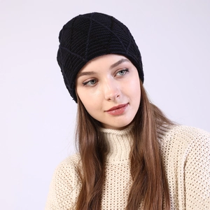 Close-up of deep blue knit beanie with diamond pattern texture on a model