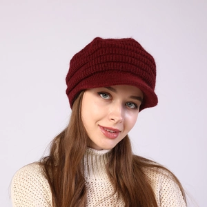 Close-up of wine red knitted beret with visor showing texture and warm winter material