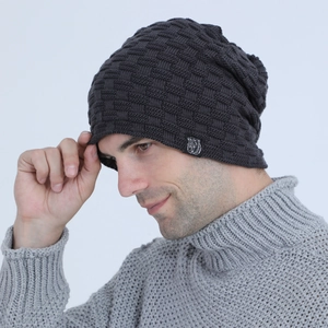Close-up of dark grey knit beanie with basket weave texture and animal logo patch