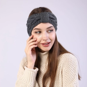 Detail of dark grey knitted headband with twist knot design for winter warmth and style