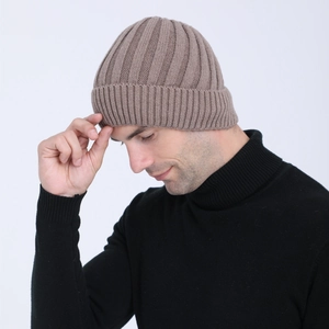 Detailed view of brown rib-knit beanie with cuff worn by model in winter style