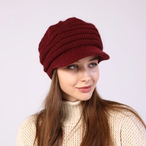 Close-up of a burgundy striped knit beret featuring thick ribbed texture and a short brim