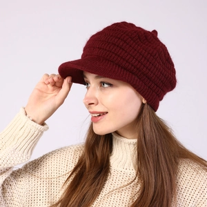 Close-up of burgundy waffle-knit wool beret showing soft textured fabric and wavy edges