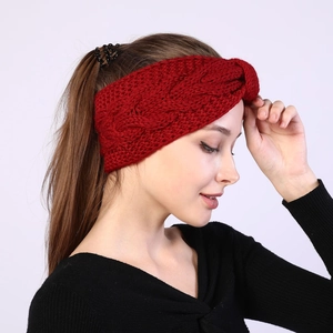 Close-up of red twist knit headband showing cable knit texture and crossover design