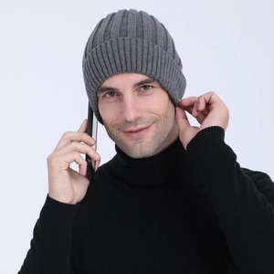 Detailed close-up of dark grey ribbed knit beanie showing ear protection and thick texture