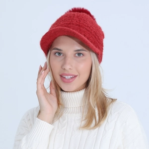 Detail of red winter knit peaked cap with fluffy pompom and thick fleece lining