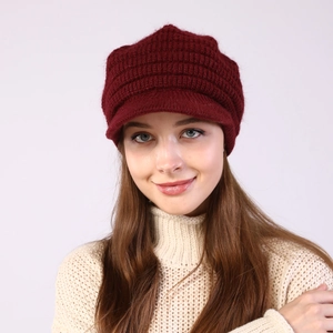 Detail of burgundy striped knit newsboy hat with plush lining on a female model