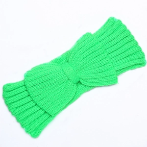 Detailed ribbed texture of bright green knitted headband with bow decoration