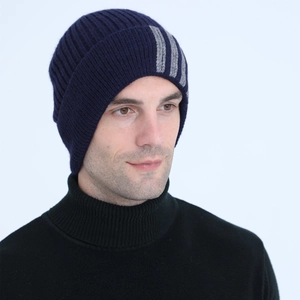 Detail view of navy blue knitted beanie with grey stripes and soft wool texture