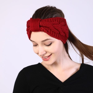 Detail of dark red cable knit headband with stylish twist knot for winter warmth