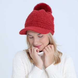 Detailed knit texture and large faux fur pompom on red winter peak beanie hat