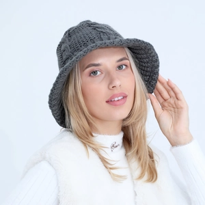 Close-up of deep gray chunky knit bucket hat showing thick wool texture and cable pattern