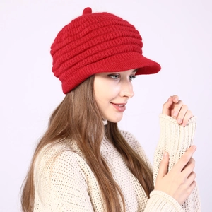 Close-up of red striped knit visor beanie with cozy fleece lining and top pom-pom