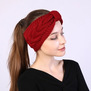 Detail of dark red cable knit headband showing twisted knot and warm wool texture