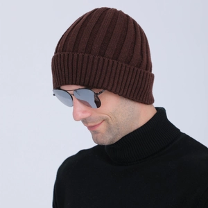 Close-up of deep brown ribbed knit beanie with thick fold-over cuff on male model