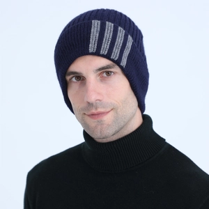 Detail of navy blue ribbed knit beanie with grey vertical stripes on a model