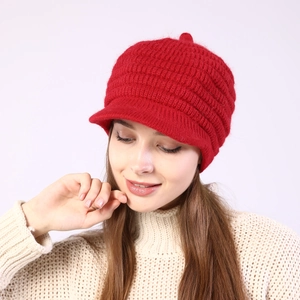 Detail of red knitted peaked beanie with pompom and thick thermal fleece lining