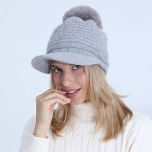 Detail view of grey cable knit winter hat with warm fleece lining and faux fur pompom