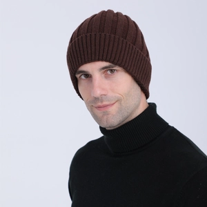 Close-up of thick ribbed knit texture on a dark brown winter beanie hat worn by male model