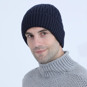 Close-up of dark blue knit beanie with cable pattern and plush lining on male model