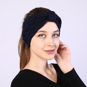 Detailed knit texture of a dark blue twisted winter headband showing cable weave pattern