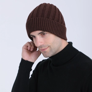 Close-up of dark brown rib-knit beanie showing the cuffed detail and wool texture