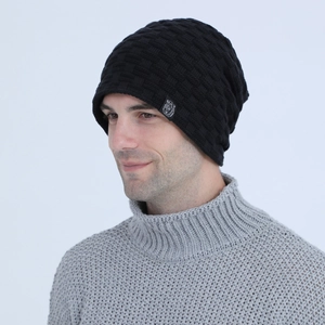 Close-up of black knitted beanie with checkered texture and bear head woven patch