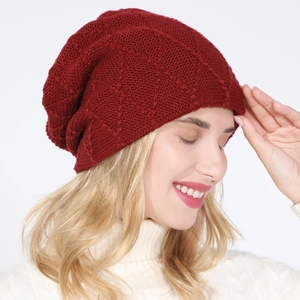 Close-up of a burgundy knit slouchy beanie with diamond grid pattern on a model