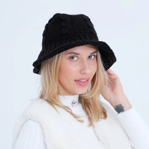 Close-up of the black knit bucket hat featuring intricate cable patterns and thick texture