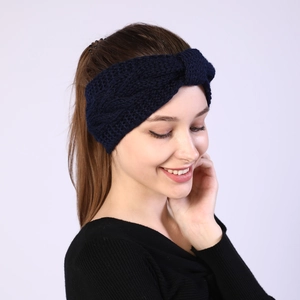 Detail of navy knit twisted headband showing thick cable pattern on a female model