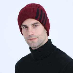 Detail of burgundy knitted beanie featuring black vertical stripes and ribbed texture