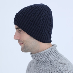 Detailed close-up of navy blue cable knit beanie with warm ribbed texture for men