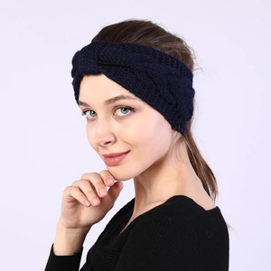 Detail of dark blue knit headband showing thick cable twist pattern and soft yarn texture