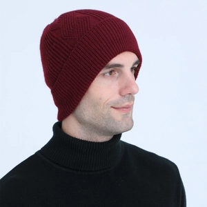 Close-up of wine red cable knit beanie showing thick texture and ribbed cuff detail
