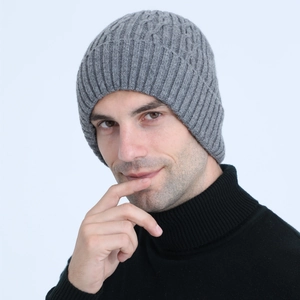 Close-up of grey cable-knit men's beanie showing thick wool texture and ribbed cuff