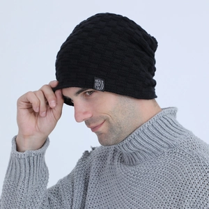 Detail of black waffle knit beanie for men with small bear logo patch on the side