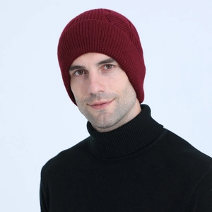 Close-up of cable knit burgundy beanie with ribbed cuff and warm winter texture