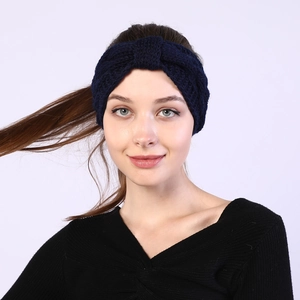 Close-up of deep blue knitted twist headband with chunky wool texture for winter
