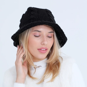 Close-up of black cable knit bucket hat with thick textured weave and warm winter fabric