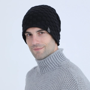 Detail of black men's knit beanie showing 3D checkered texture and round animal tag