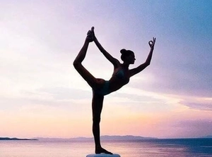 Silhouette of long stirrup leg warmers on yoga model at sunset outdoor beach scene