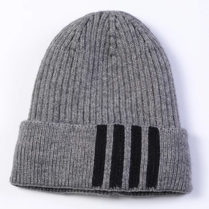Detail of the gray knit hat featuring black vertical stripes on the cuff and soft wool texture