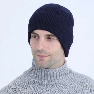 Detailed close-up of dark blue cable knit beanie showing thick ribbed texture and warmth